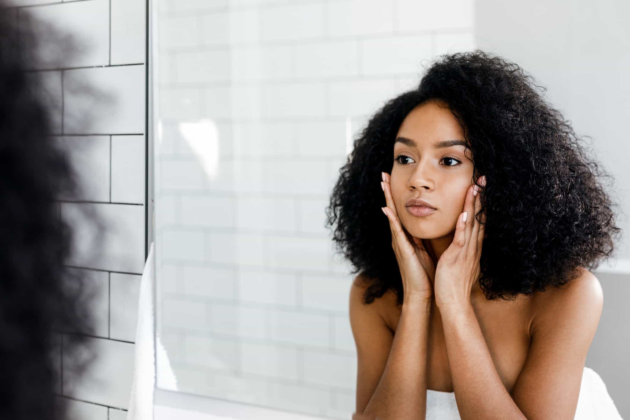 Beautiful woman looking at herself in the mirror