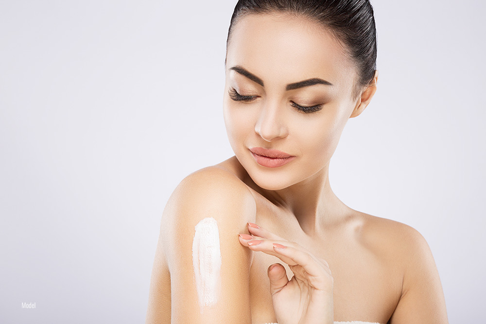 woman applying sunscreen on her body